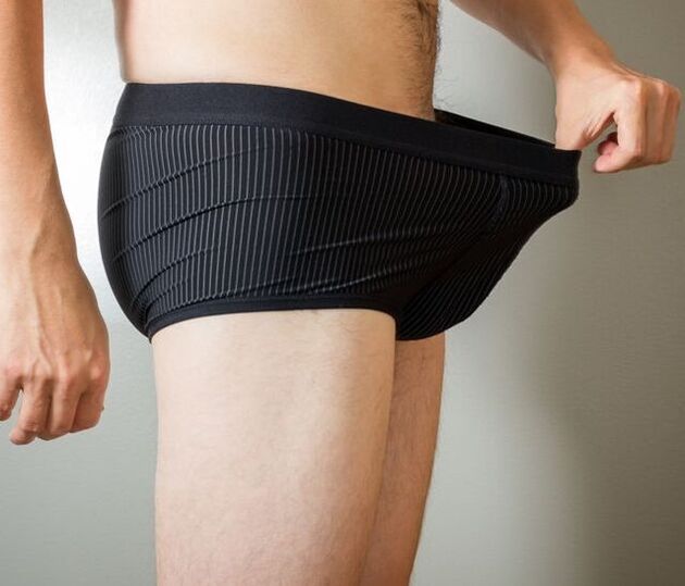 Un home mira a súa roupa interior tras unha cirurxía de ampliación do pene